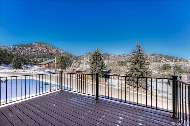 wooden deck with a mountain view and a covered pool