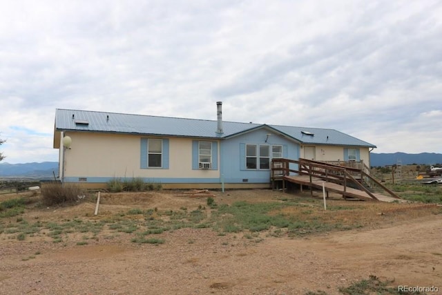 rear view of house featuring a deck with mountain view