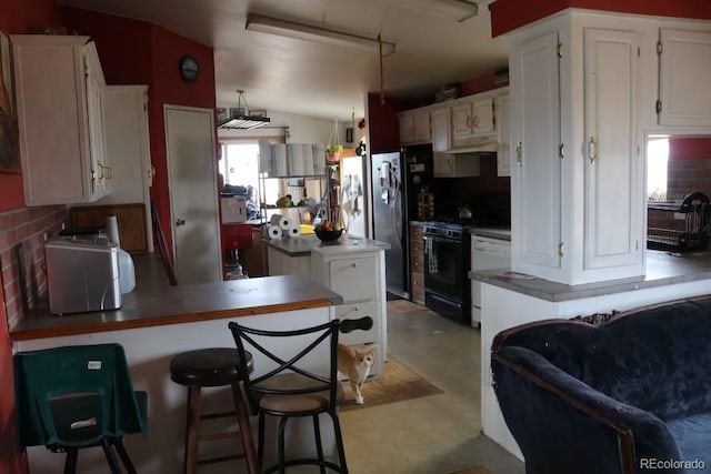 kitchen with white cabinets, dishwasher, decorative backsplash, black range with gas cooktop, and kitchen peninsula