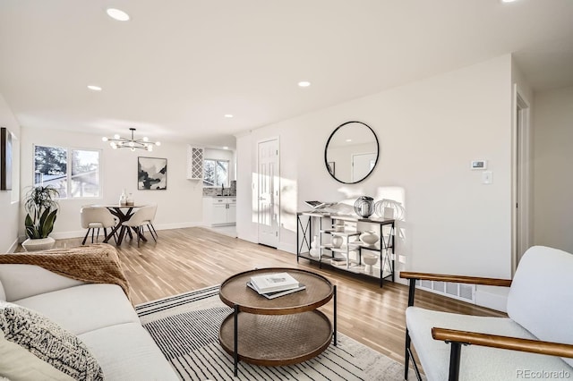 living room featuring an inviting chandelier and light wood-type flooring