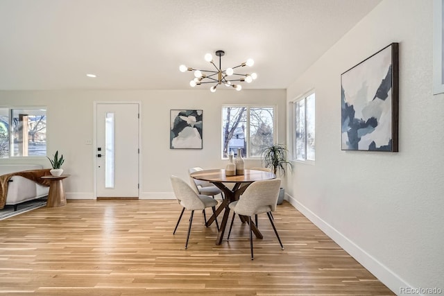 dining area featuring a notable chandelier and light wood-type flooring