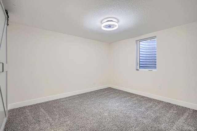 carpeted spare room featuring a textured ceiling