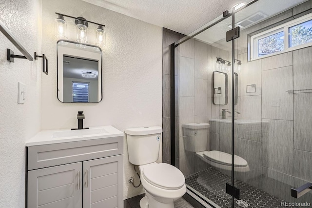 bathroom with a textured ceiling, an enclosed shower, vanity, and toilet