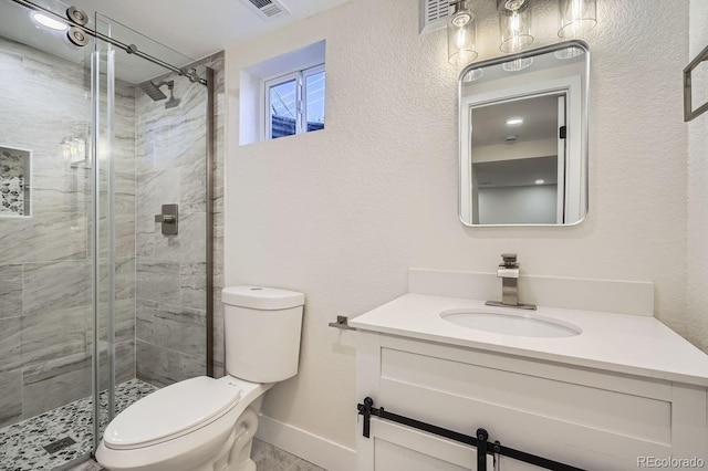 bathroom with toilet, vanity, and a shower with shower door