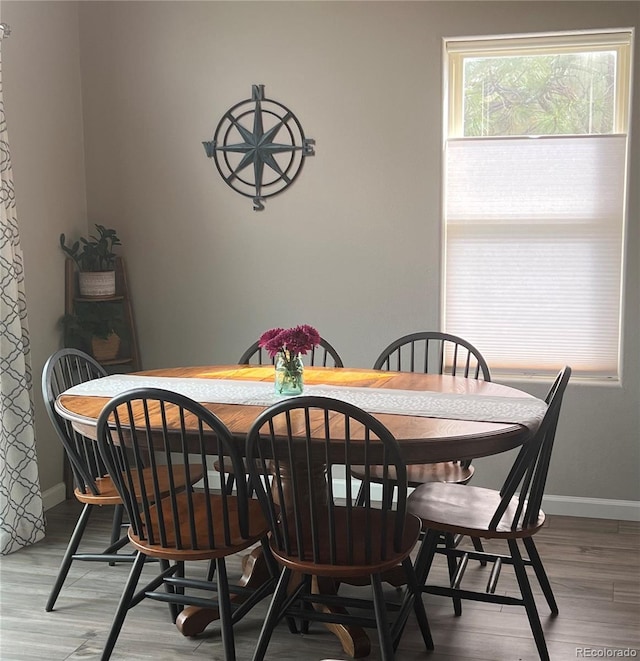 dining area with light wood finished floors and baseboards