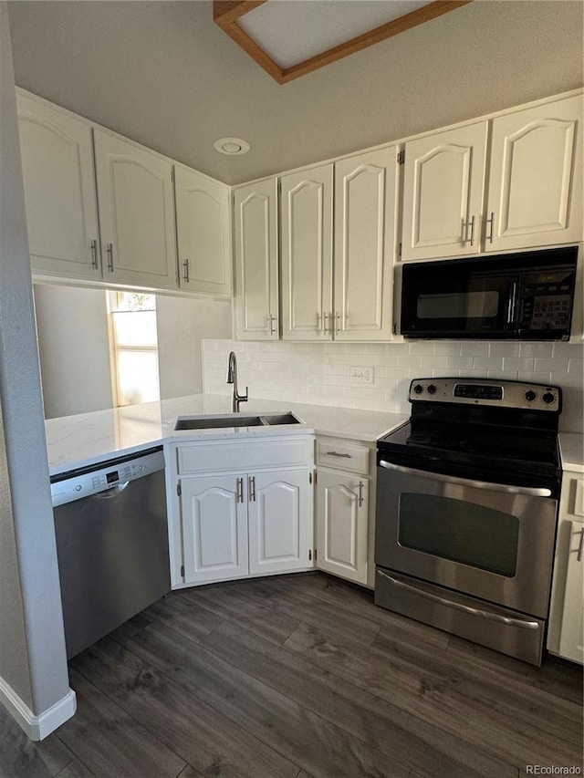 kitchen with stainless steel appliances, white cabinetry, a sink, and tasteful backsplash