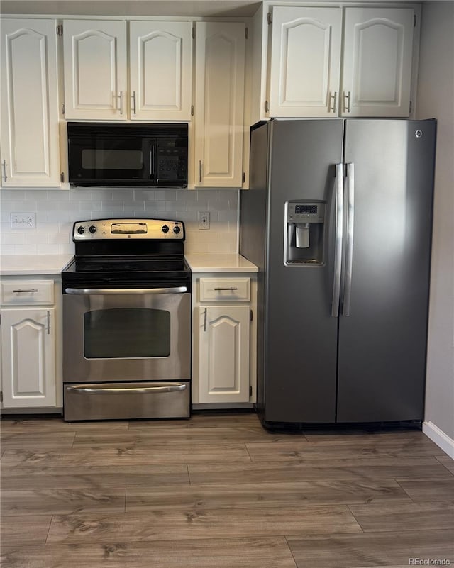 kitchen with appliances with stainless steel finishes, light countertops, and decorative backsplash