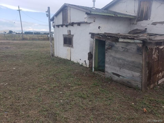 view of side of home featuring a yard and stucco siding