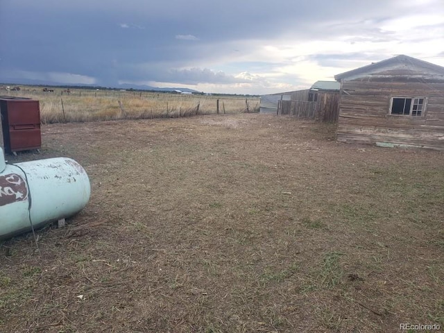 view of yard with a rural view and fence