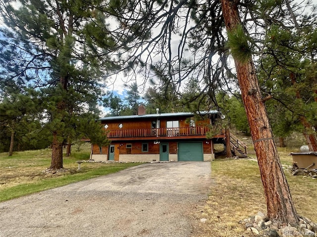 chalet / cabin featuring a chimney, a garage, driveway, a wooden deck, and stairs