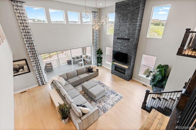 423 Rogers Way, Castle Rock, CO 80104 - living room with wood finished floors, a fireplace, a high ceiling, and a chandelier