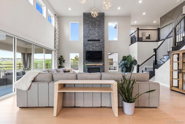 423 Rogers Way, Castle Rock, CO 80104 - living area with a towering ceiling, a fireplace, wood finished floors, recessed lighting, and stairway