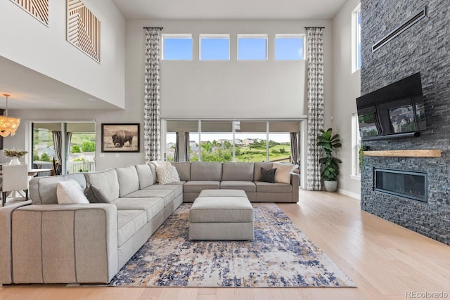 423 Rogers Way, Castle Rock, CO 80104 - living area with a towering ceiling, wood finished floors, a chandelier, and a stone fireplace