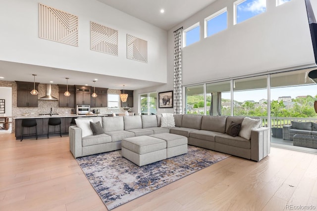 423 Rogers Way, Castle Rock, CO 80104 - living area featuring light wood-style floors, a high ceiling, and recessed lighting