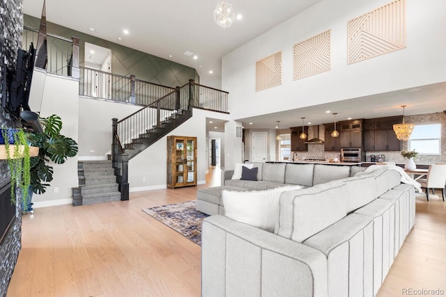423 Rogers Way, Castle Rock, CO 80104 - living room with a high ceiling, light wood finished floors, stairway, a chandelier, and recessed lighting