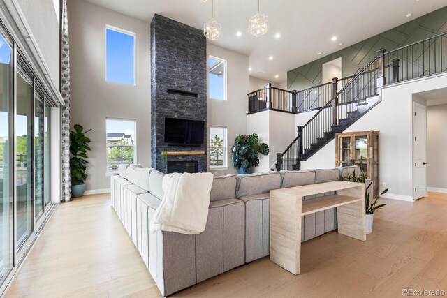 423 Rogers Way, Castle Rock, CO 80104 - living area featuring a high ceiling, light wood-style floors, a fireplace, recessed lighting, and a chandelier