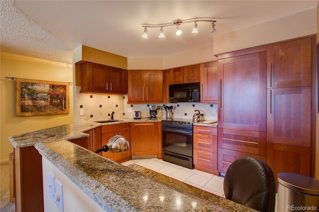 kitchen with tasteful backsplash, light stone countertops, sink, black appliances, and light tile patterned flooring