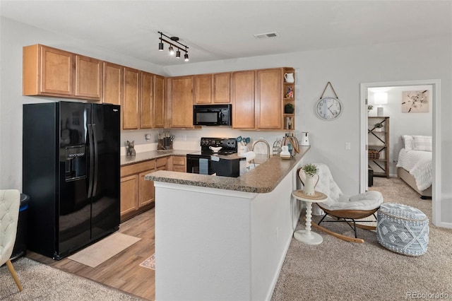 23346 E 5th Pl Unit 101, Aurora, CO 80018 - kitchen with black appliances, open shelves, a peninsula, a sink, and light colored carpet