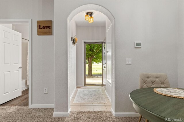 23346 E 5th Pl Unit 101, Aurora, CO 80018 - carpeted entryway with arched walkways, baseboards, and a textured wall