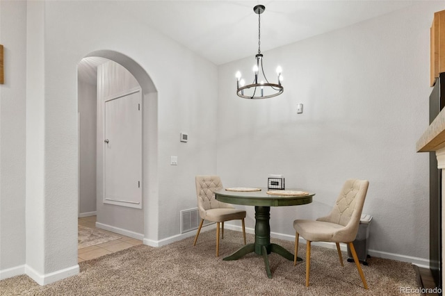 23346 E 5th Pl Unit 101, Aurora, CO 80018 - carpeted dining area with arched walkways, a chandelier, baseboards, and tile patterned flooring