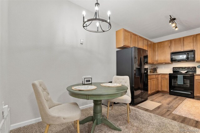 23346 E 5th Pl Unit 101, Aurora, CO 80018 - kitchen with black appliances, a chandelier, light wood-style flooring, baseboards, and light countertops