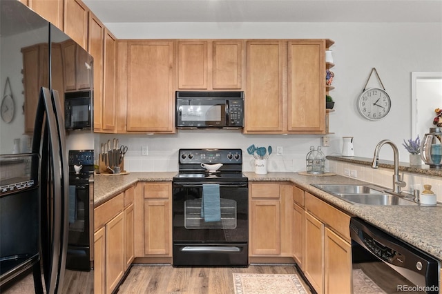 23346 E 5th Pl Unit 101, Aurora, CO 80018 - kitchen featuring black appliances, a sink, light wood-style floors, light countertops, and a peninsula