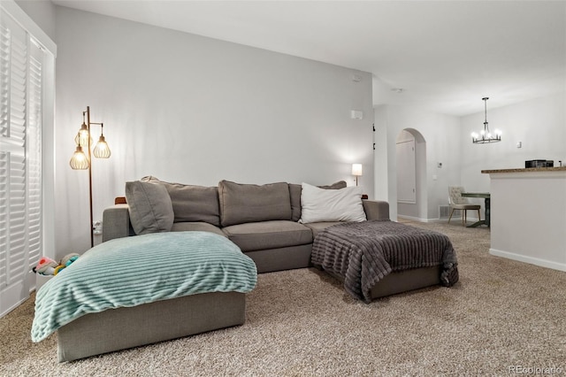 23346 E 5th Pl Unit 101, Aurora, CO 80018 - carpeted living room featuring arched walkways, a chandelier, and baseboards