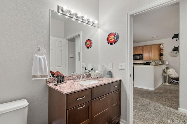 23346 E 5th Pl Unit 101, Aurora, CO 80018 - bathroom featuring vanity, toilet, and a textured wall
