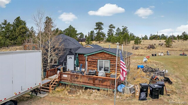view of front of house with a deck and roof with shingles