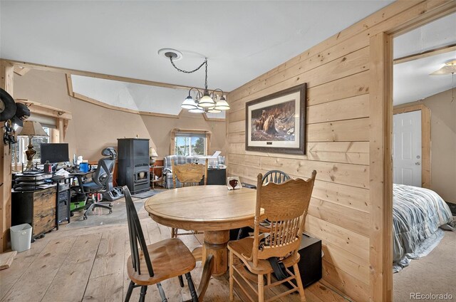 dining area with light wood-style flooring and wood walls