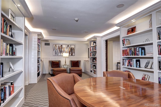 dining space with built in shelves, a wainscoted wall, and carpet flooring