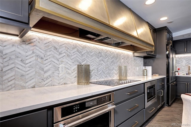 kitchen featuring recessed lighting, appliances with stainless steel finishes, custom exhaust hood, dark wood-style floors, and tasteful backsplash