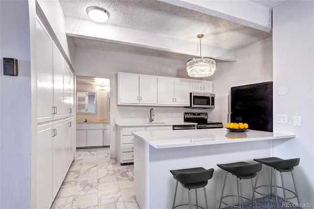 kitchen with marble finish floor, stainless steel appliances, a breakfast bar, and a sink