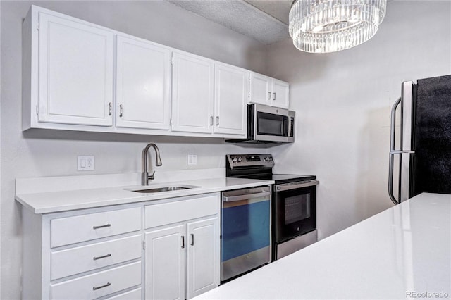 130 N Pearl St Unit 1606, Denver, CO 80203 - kitchen featuring stainless steel appliances, a sink, light countertops, white cabinetry, and a chandelier