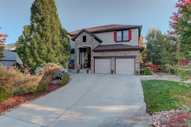 5033 Silver Feather Way, Broomfield, CO 80023 - view of front of home featuring stone siding, driveway, an attached garage, and stucco siding