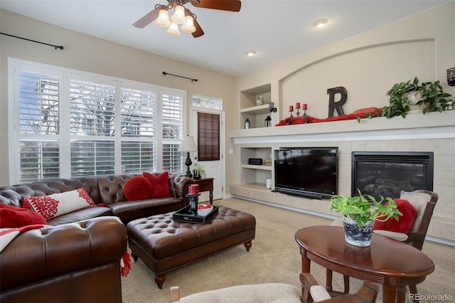 living room featuring a fireplace, ceiling fan, built in features, and carpet