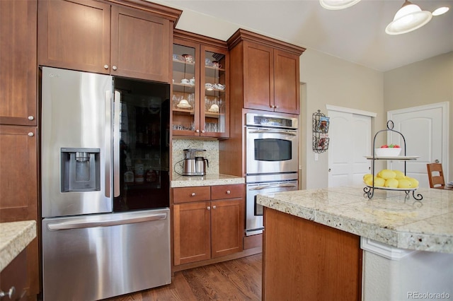 kitchen featuring tasteful backsplash, wood-type flooring, and appliances with stainless steel finishes