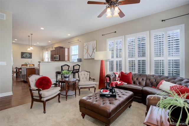 living room with ceiling fan and light hardwood / wood-style flooring