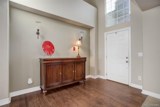 foyer with a towering ceiling and dark hardwood / wood-style floors