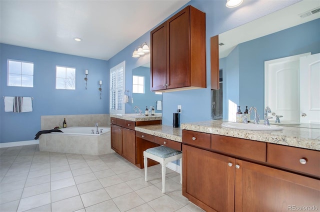 bathroom with tile patterned floors, a relaxing tiled tub, and vanity