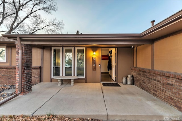 view of exterior entry featuring a patio