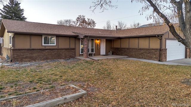 ranch-style home with a garage and a front lawn