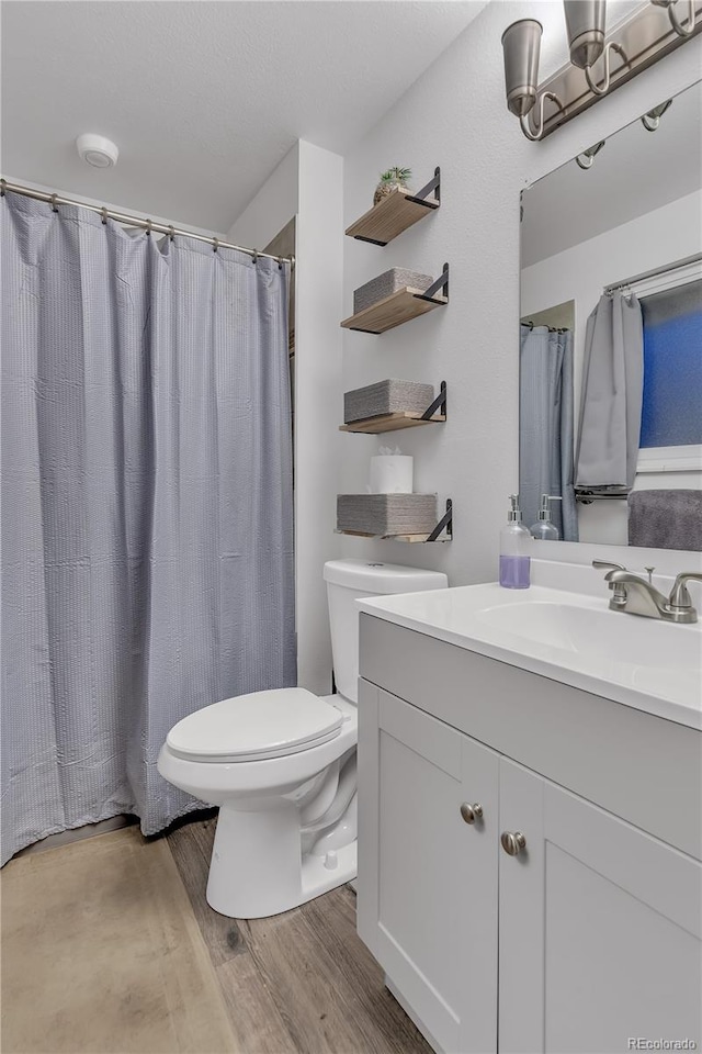 bathroom with hardwood / wood-style floors, vanity, and toilet