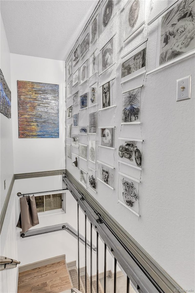 stairway featuring a textured ceiling