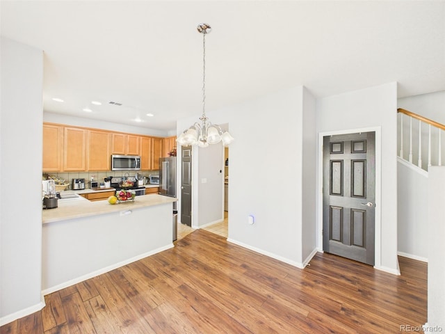 12912 Grant Cir Unit A, Thornton, CO 80241 - kitchen featuring stainless steel appliances, light countertops, a chandelier, wood finished floors, and recessed lighting