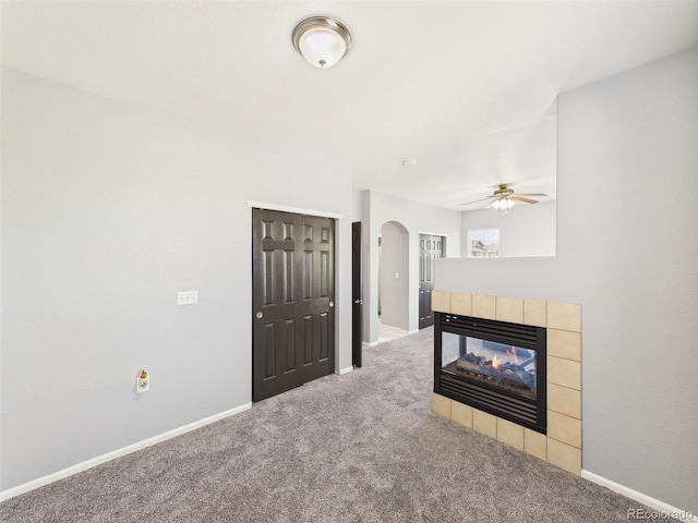12912 Grant Cir Unit A, Thornton, CO 80241 - unfurnished living room featuring arched walkways, carpet, ceiling fan, and a fireplace