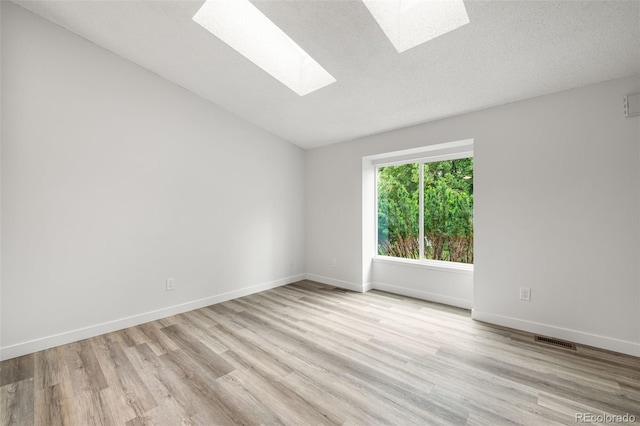 2777 S Sedalia St, Aurora, CO 80013 - empty room with a skylight, wood finished floors, and vaulted ceiling
