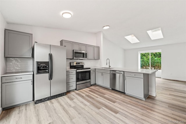 2777 S Sedalia St, Aurora, CO 80013 - kitchen with appliances with stainless steel finishes, gray cabinets, a skylight, lofted ceiling, and a peninsula