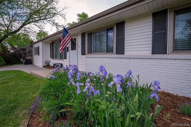 4425 E Harvard Ave, Denver, CO 80222 - view of side of home with brick siding, a lawn, and a patio area