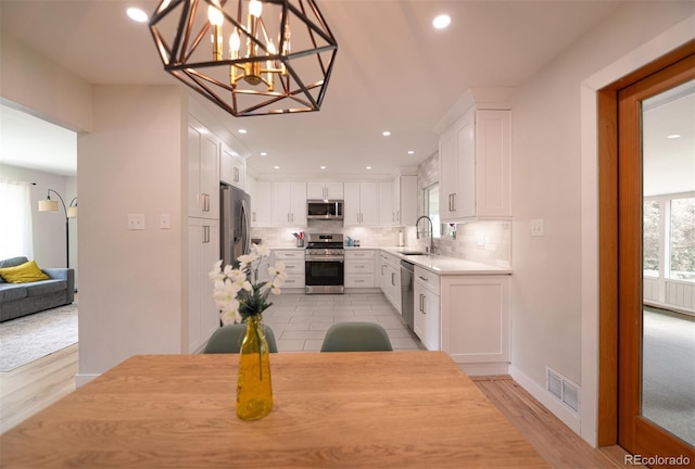 4425 E Harvard Ave, Denver, CO 80222 - dining space with a chandelier, light wood-style flooring, and recessed lighting